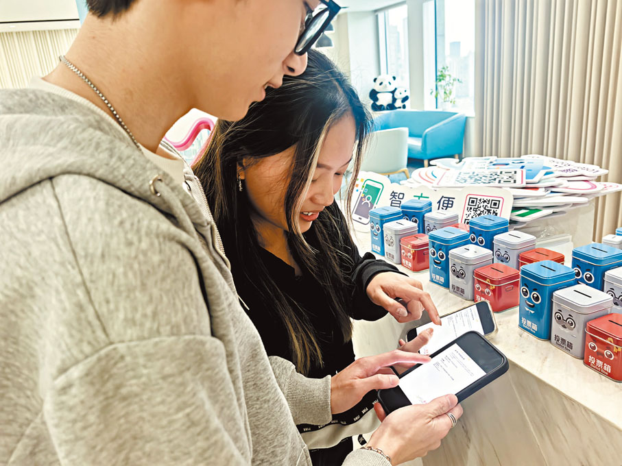 ●青年學子對於手機App使用非常熟悉,只用了幾分鐘就完成了選民登記。香港文匯報記者張帆 攝