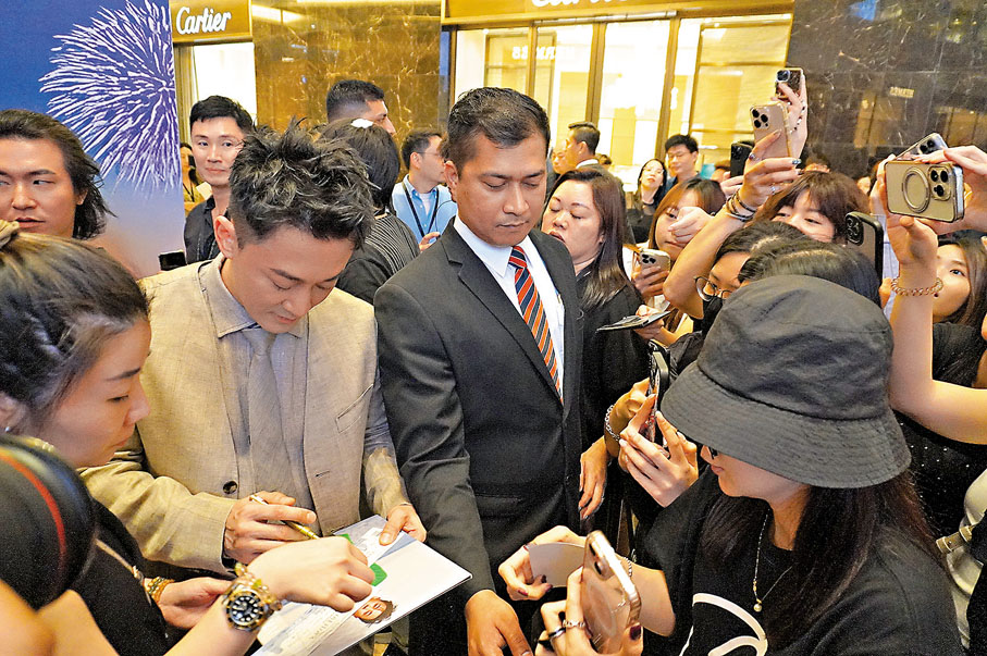 ●林峯為圍觀粉絲簽名。  子棠 攝