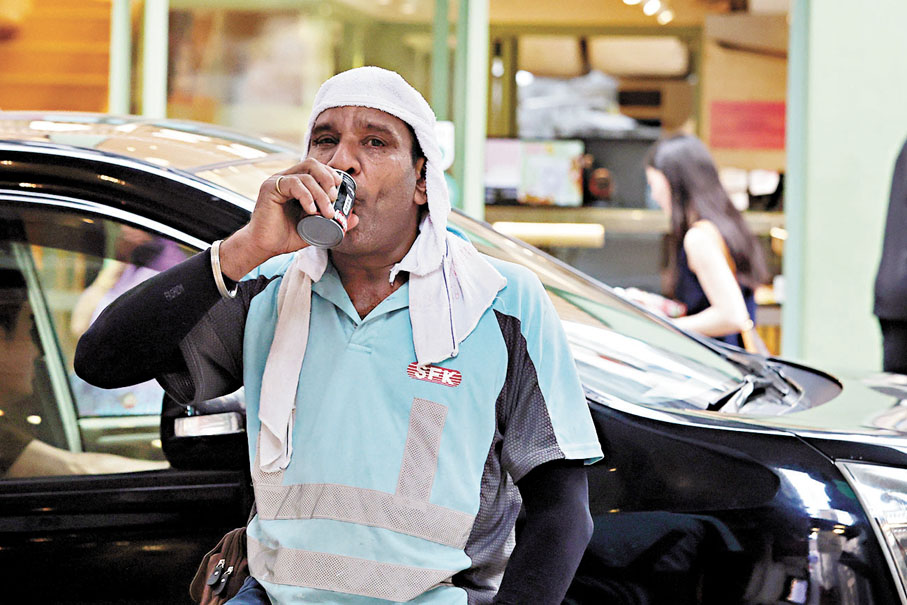 ●工友喝罐裝凍咖啡消暑。香港文匯報記者萬霜靈 攝