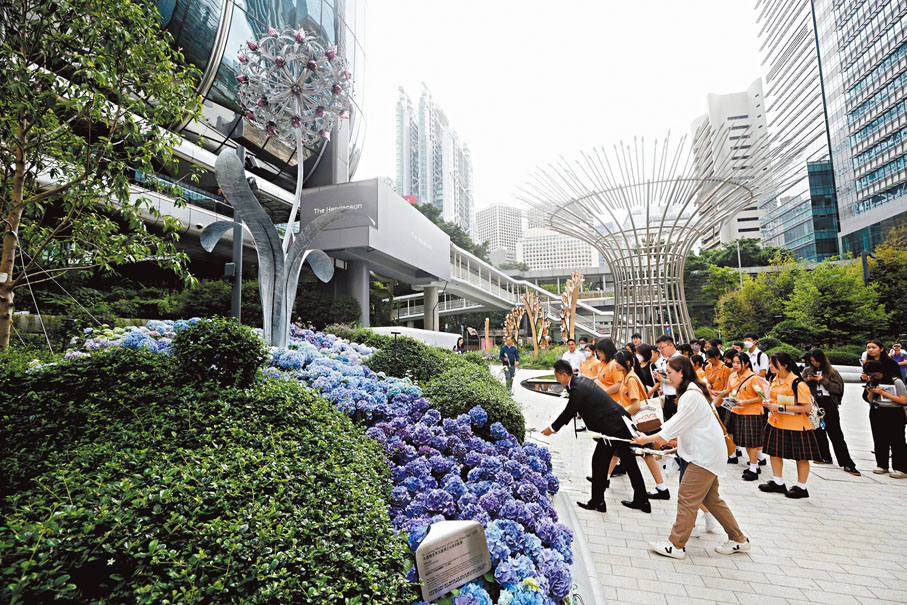 ●市民與學生在紀念花園向李兆基獻花致意。香港文匯報記者郭木又  攝