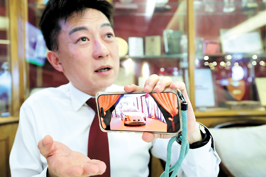 ●何緯豐接受香港文匯報專訪，分享紅旗汽車在中東8年深耕的經驗。圖為何緯豐展示紅旗在中東的宣傳片。 香港文匯報記者北山彥 攝