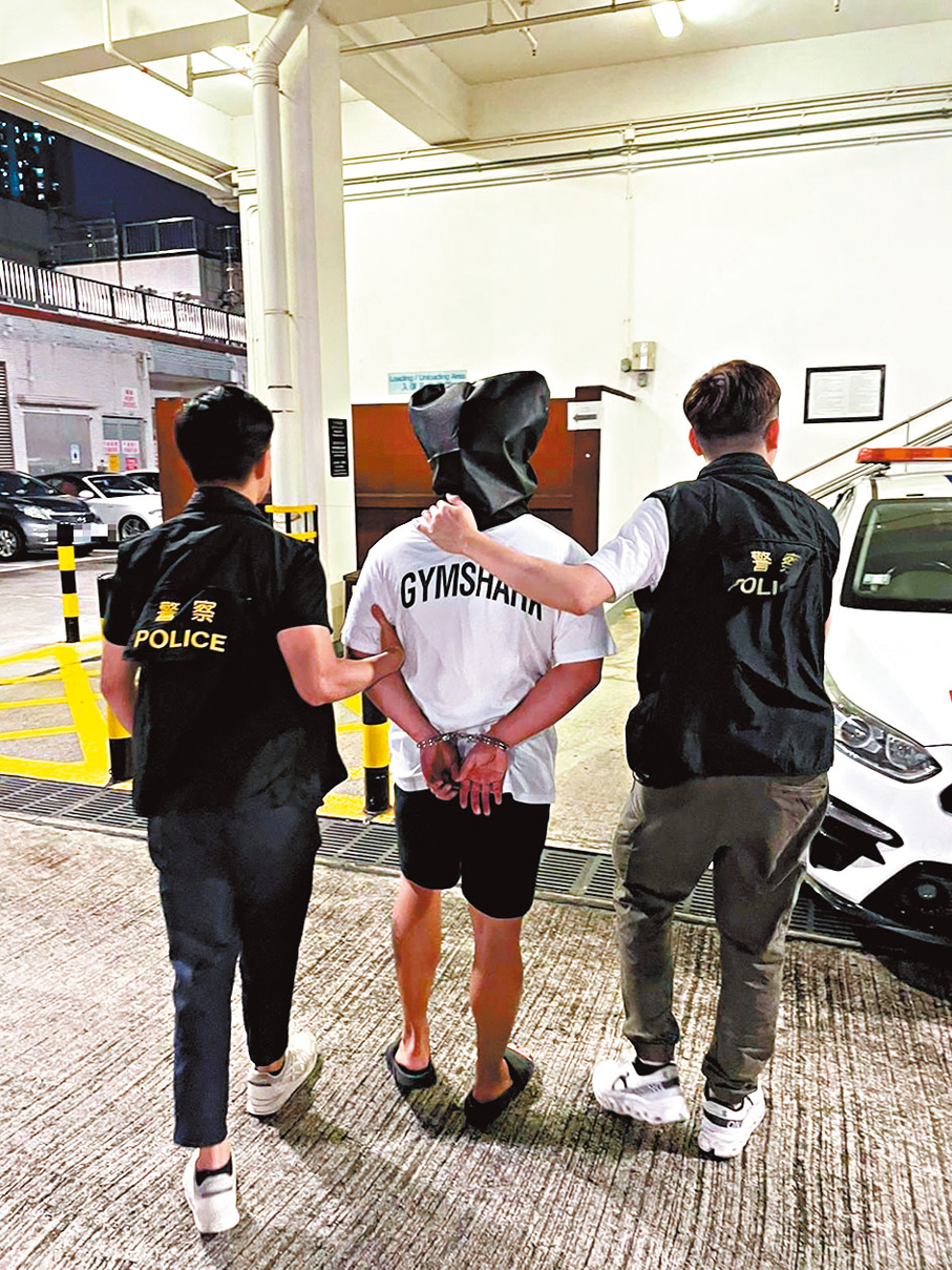 ●探員將一名被捕疑犯帶返警署扣查。