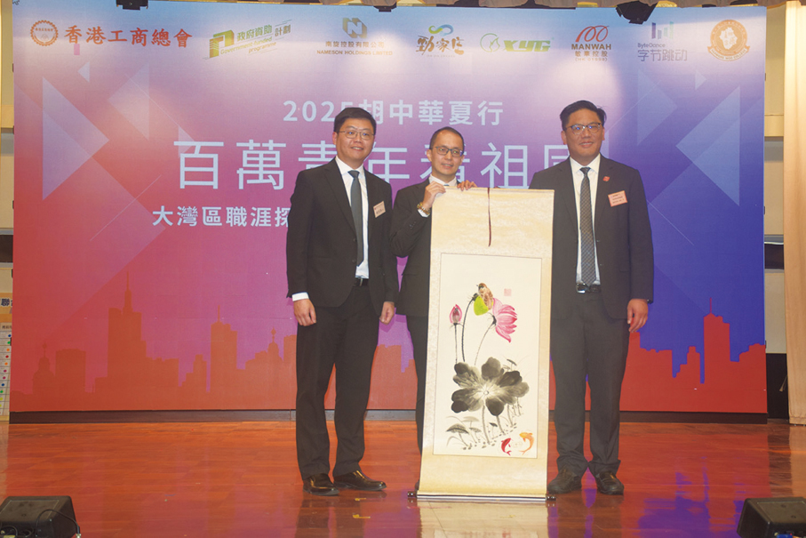 ●胡兆熾中學校長趙家豪（左）和梁宏正（右），向演講嘉賓李國強致送師生繪畫的水墨畫。