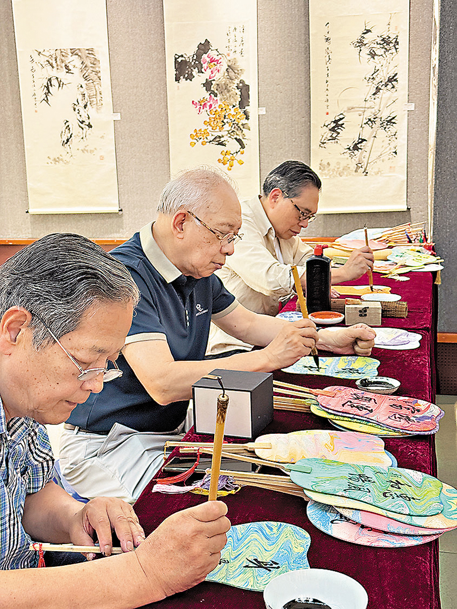 ●來自香港及內地的書畫家一起參加公益義演活動，書畫家在扇面上題字。   黃寶儀 攝