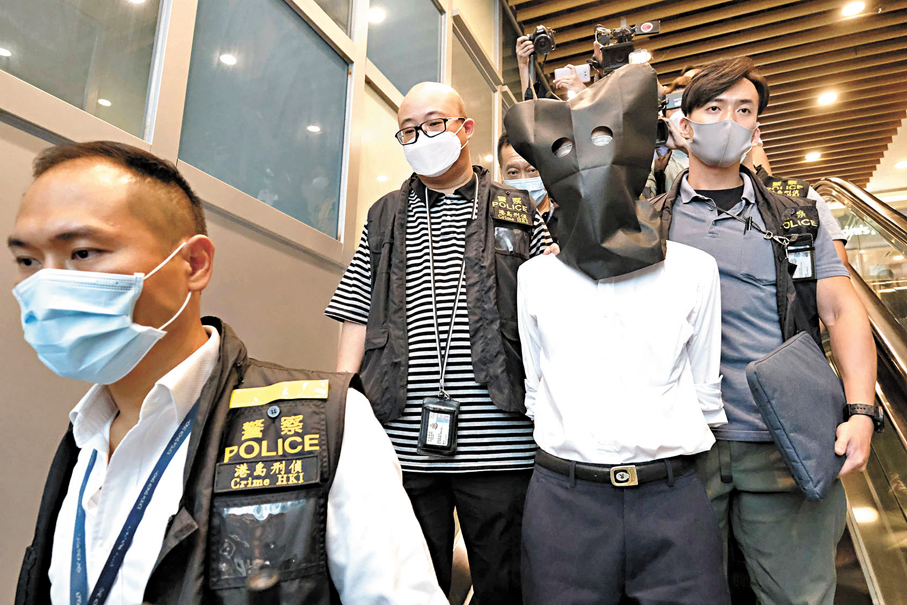 ●警方當日拘捕王秉亮，以黑布頭套蒙頭及鎖上手銬將其帶走。 資料圖片