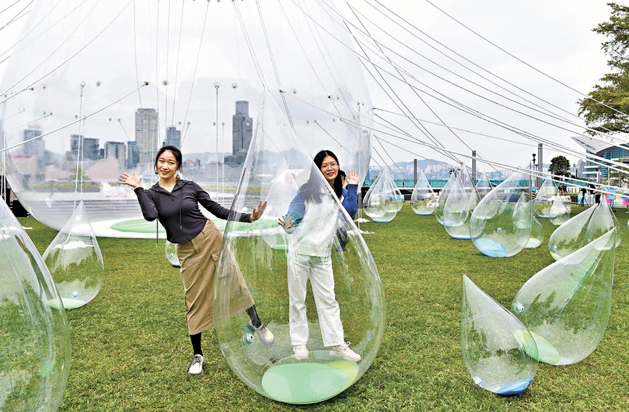 ●觀眾在香港添馬公園舉行的「舞動水滴展」留影，該大型藝術裝置展覽是藝術家馬興文特別為慶祝東江水供港60周年而創作。 資料圖片