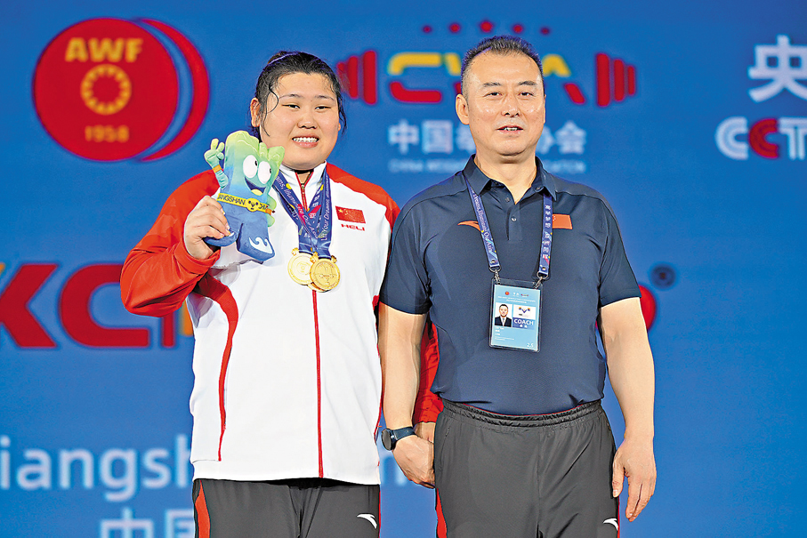 ●李閆（左）與教練劉堯在頒獎儀式後合影。  新華社