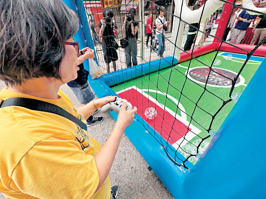 ●李婆婆首次試玩無人機足球。香港文匯報記者洪澤楷  攝