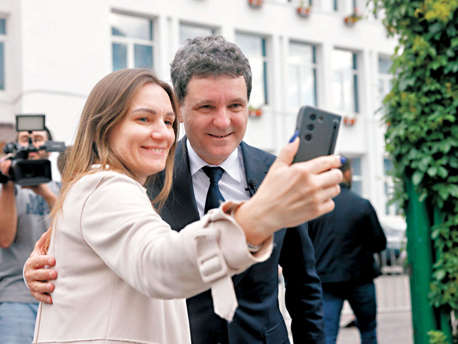 ●達恩（右）在票站外與支持者合照。彭博社