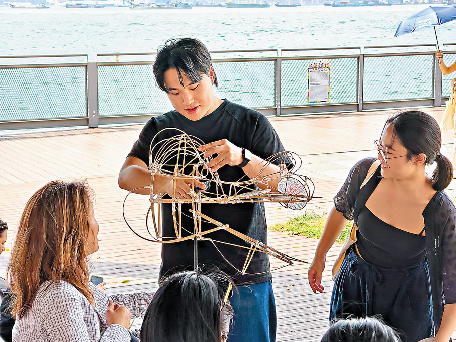 ●洪梓維（中）與謝旻蒑（右）指導參與者進行紮作。