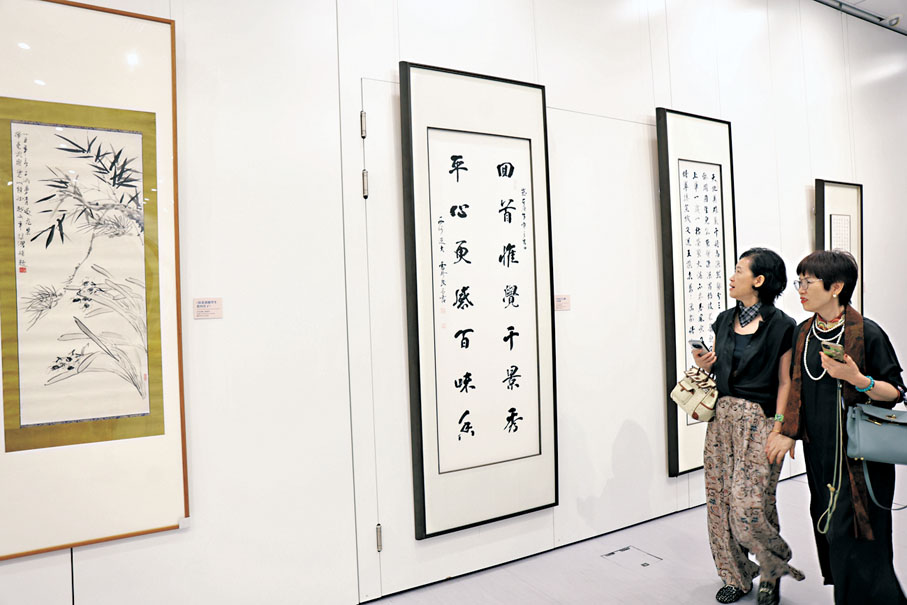 ●觀眾細心欣賞畫作。 萬霜靈 攝