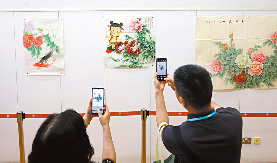 ●市民以手機拍攝畫作。香港文匯報記者郭木又  攝