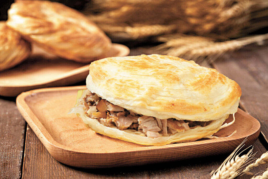 ●「餅子千層酥脆、焦黃掉渣，滷肉肥而不膩、瘦而不柴」的潼關肉夾饃如今已成為享譽海內外的中華名小吃。香港文匯報陝西傳真