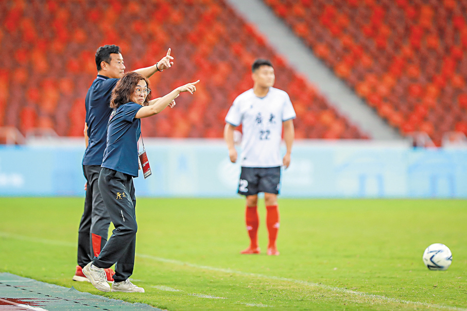 ●賽場邊，黃月堅（前）的手部動作大，表情「誇張」，希望盡最大努力讓球員接收到指令。 香港文匯報佛山傳真