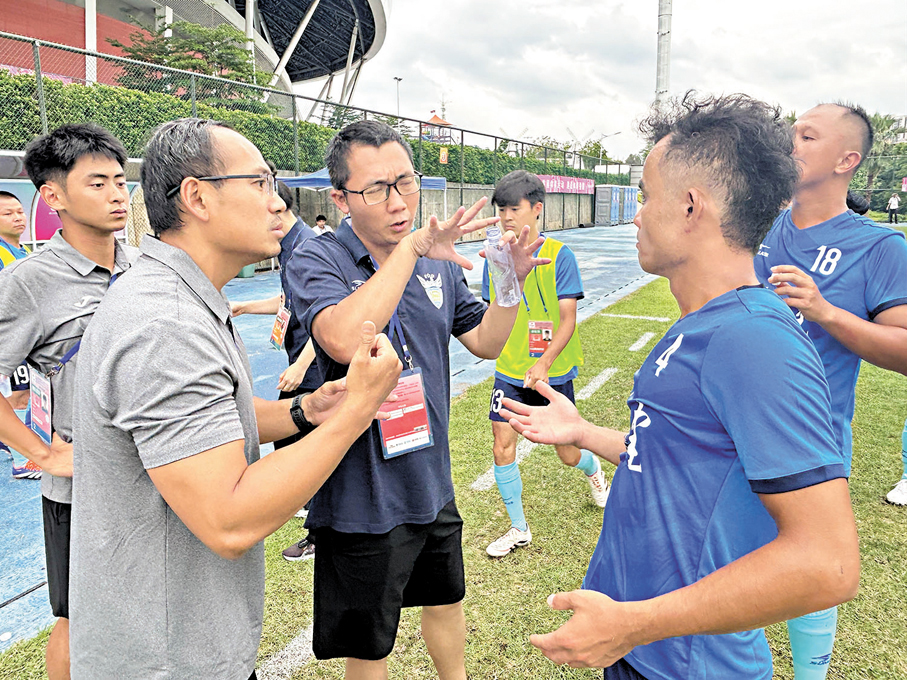 ●福建聾人足球隊兼職隨隊翻譯藍維暉（左三）在向球員翻譯教練的技戰術安排。 香港文匯報記者敖敏輝  攝