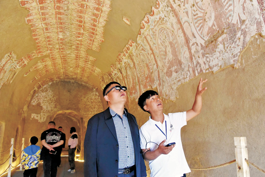 ●遊客在吐魯番雅爾湖石窟裏，戴着VR眼鏡體驗壁畫數字化復原。