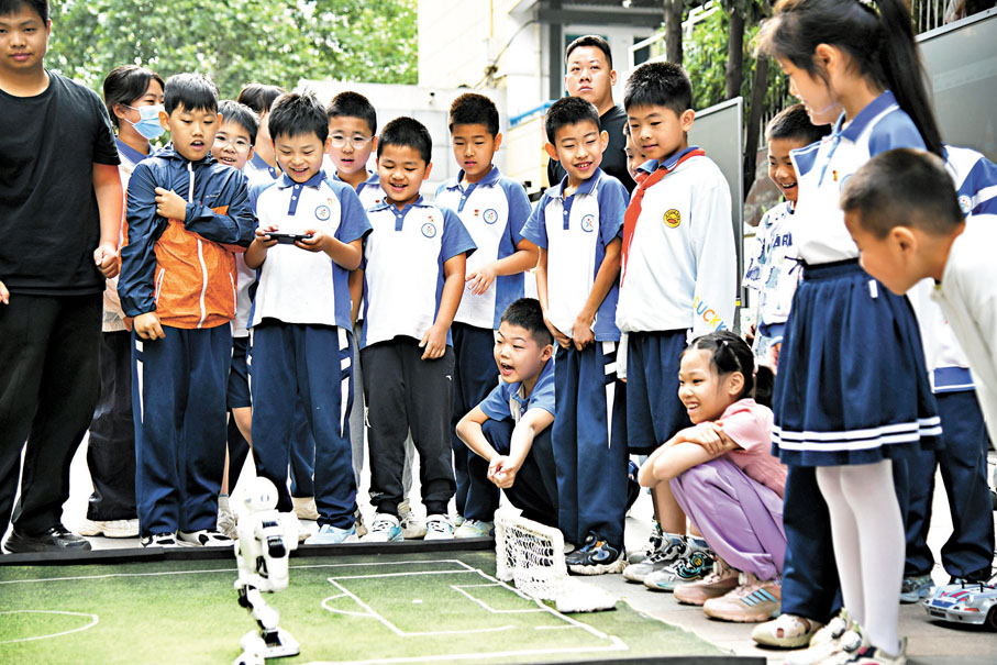 ●5月26日,在西安市新城區華山實驗小學,學生在老師的指導下體驗機器人足球。 新華社