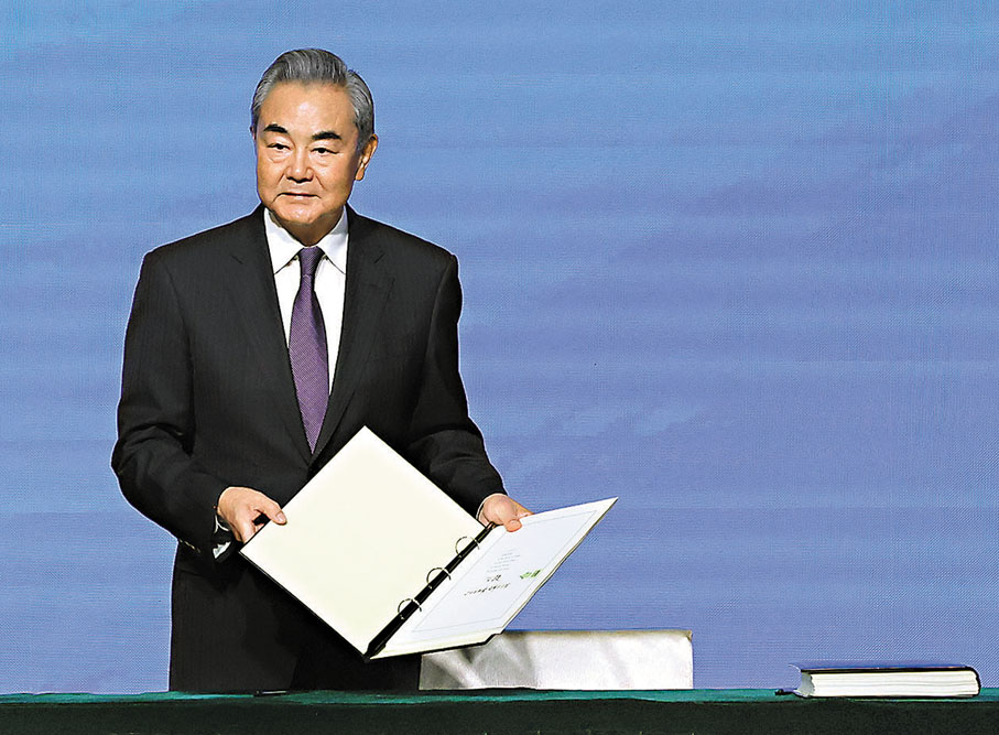 ●《關於建立國際調解院公約》簽署儀式昨日在香港舉行。圖為王毅簽署後展示公約。香港文匯報記者曾興偉  攝