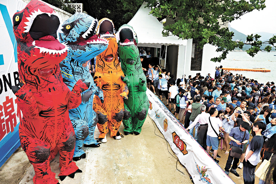 ●有人扮演充氣恐龍炒熱氣氛。 香港文匯報記者莫雪芝  攝