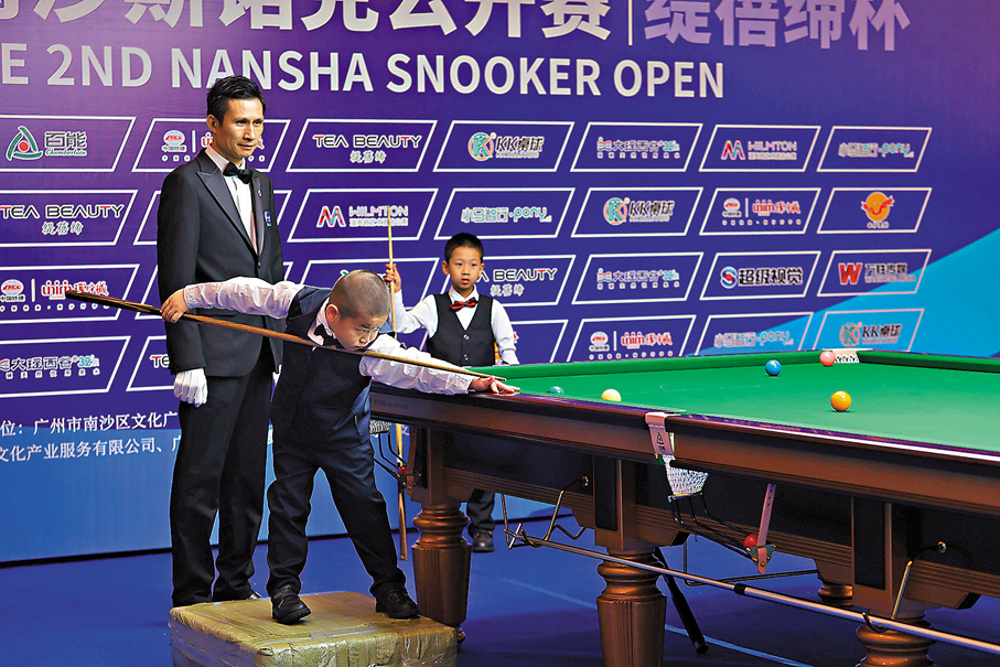 ●吳一人踩着「增高墊」打斯諾克比賽。 香港文匯報東莞傳真