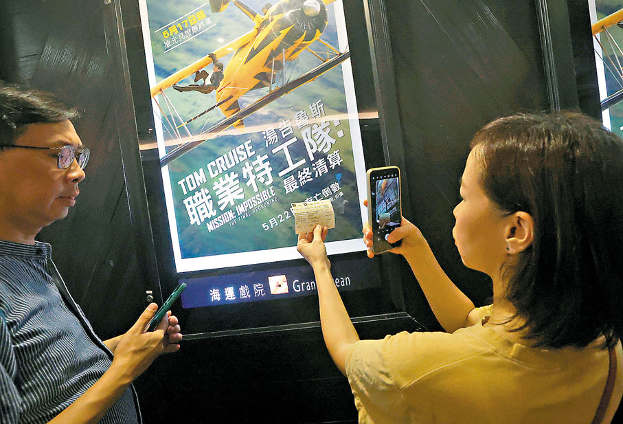 ●市民拍攝戲票和海報。 香港文匯報記者郭木又  攝