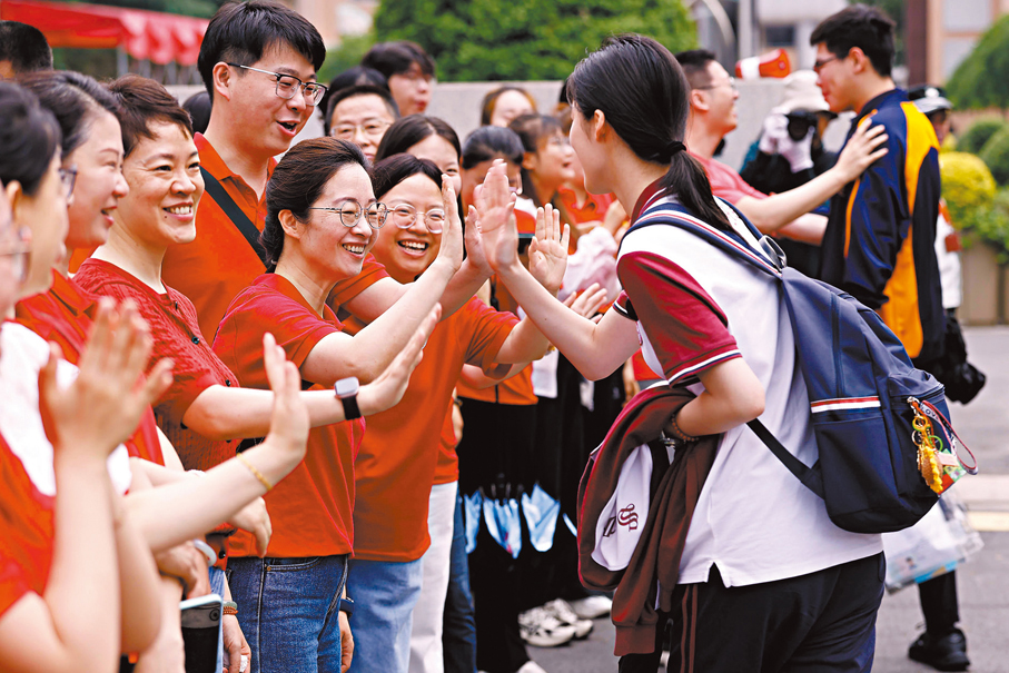 ●6月7日,上海市七寶中學考點外,送考老師為考生加油。 中新社