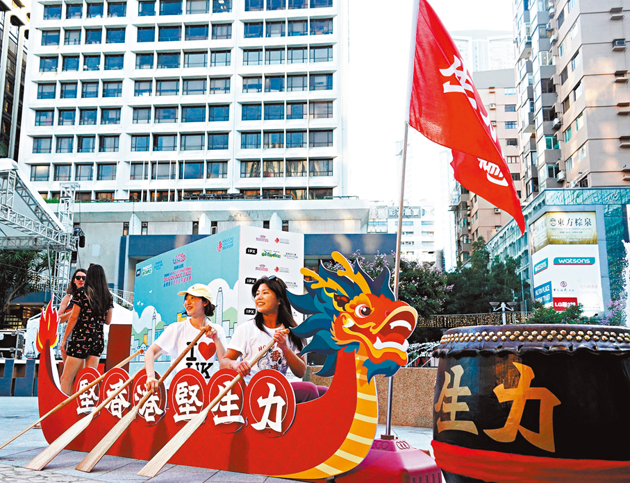 ●市民和旅客模仿扒龍舟動作打卡。