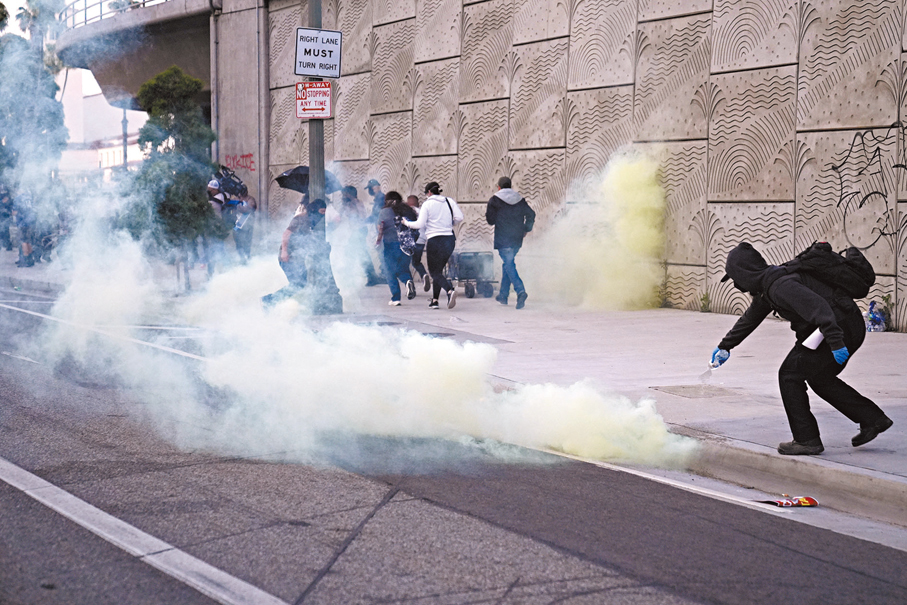 ●一名示威者向催淚彈淋水。 美聯社