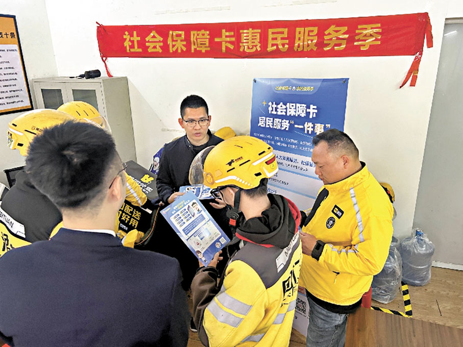 ●「民生10條」聚焦將更多人群納入社會保障覆蓋範圍。圖為廣東省江門市,工作人員在騎手驛站中為外賣騎手辦理社保卡。 網上圖片
