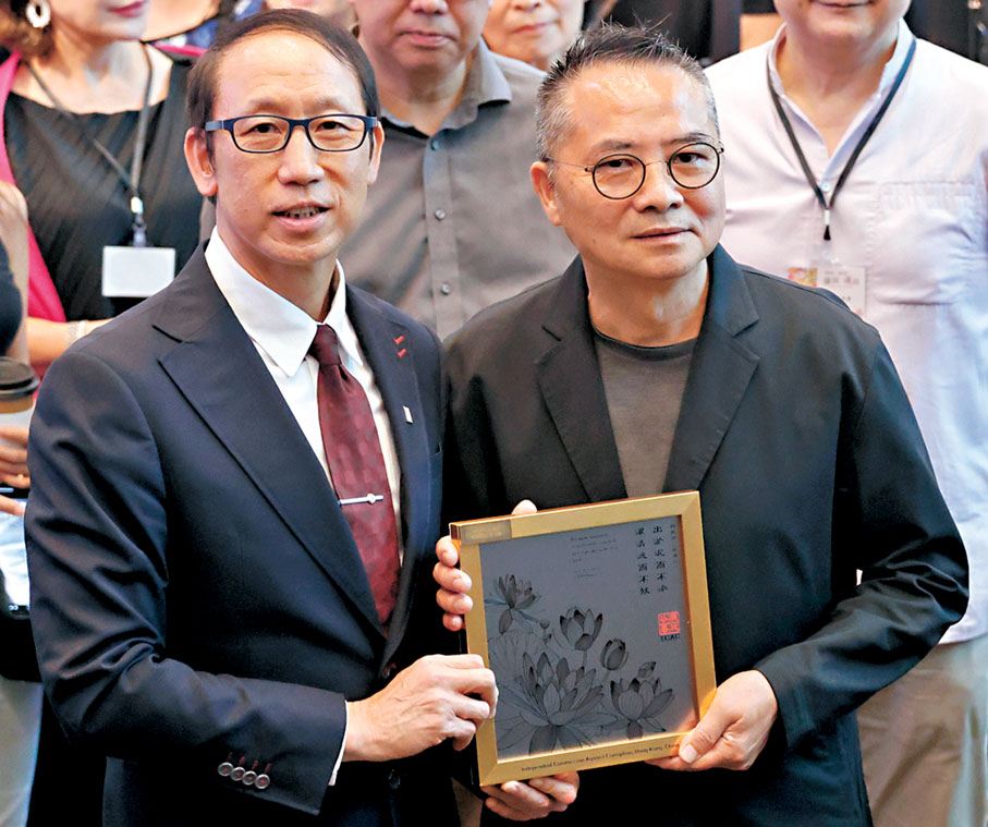 ●麥偉強（左）向林天行贈送展覽紀念品。