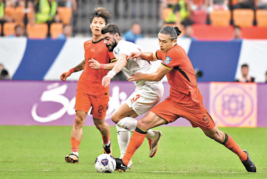 ●國足前鋒張玉寧（右）和巴林隊球員瓦利德·哈亞姆（中）在比賽中拚搶。 新華社