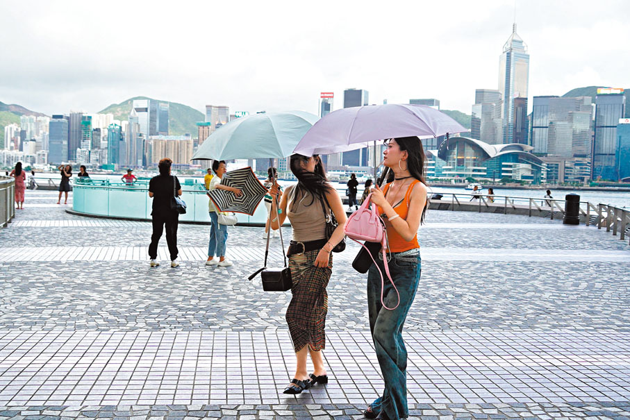 ●市民在雨中打傘。香港文匯報記者郭木又 攝