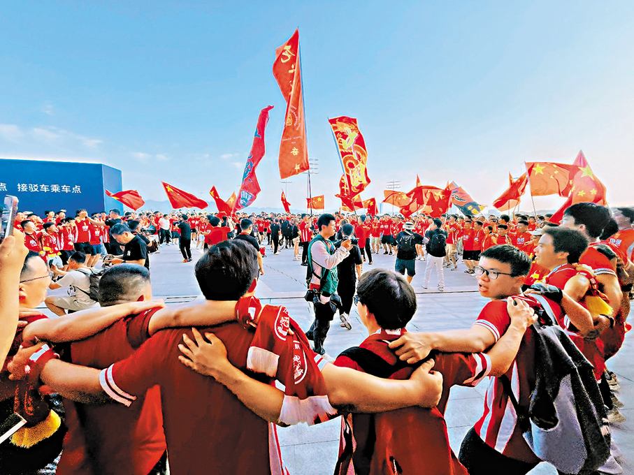 ●球迷在場外圍圈唱歌吶喊，場面熱血沸騰。香港文匯報記者韓毅  攝