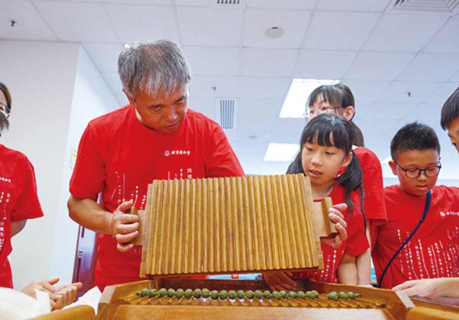 ●學員跟隨非遺傳承人學習搓製中藥蜜丸，體驗非遺技藝。