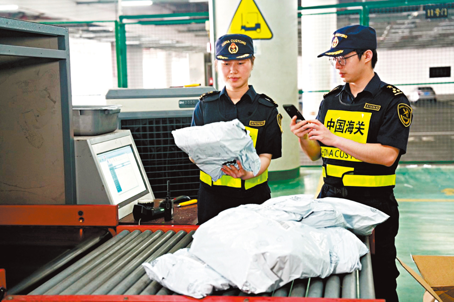 ●今年頭五個月,港珠澳大橋跨境電商出口同比大增。圖為海關關員查驗電商包裹。 香港文匯報珠海傳真