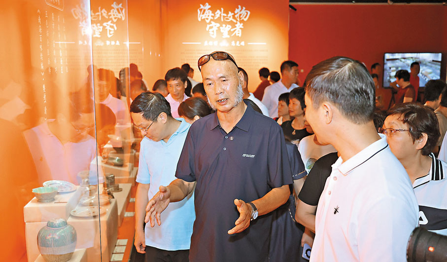 ●「器載歸途——莊銘博高克娟伉儷海外收藏捐贈特展」上,莊銘博(藍衣者)與文物愛好者交流。