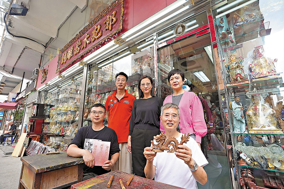 ●郭記木器雕刻第五代傳人郭一邊（前排右）與弟弟郭一天（後排左一）。他們手工雕製的作品深受各地客人歡迎。 香港文匯報記者曾興偉  攝