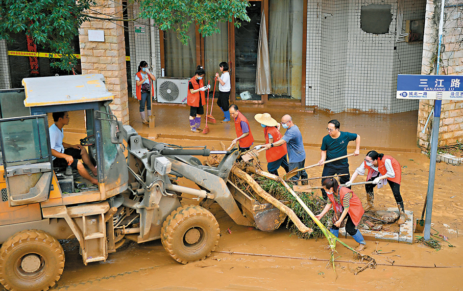 ● 6月19日，志願者在廣東省肇慶市懷集縣城的三江路清理洪水後遺留的雜物。 新華社