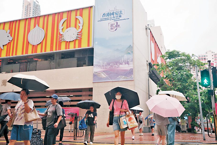 ●夏主任勉勵特區政府繼續努力，堅定維護國家安全，統籌安全及發展，用好現時安全穩定的局面，集中精力拚經濟、謀發展、惠民生。圖為街市外展示的巨型直幡海報。香港文匯報記者郭木又  攝