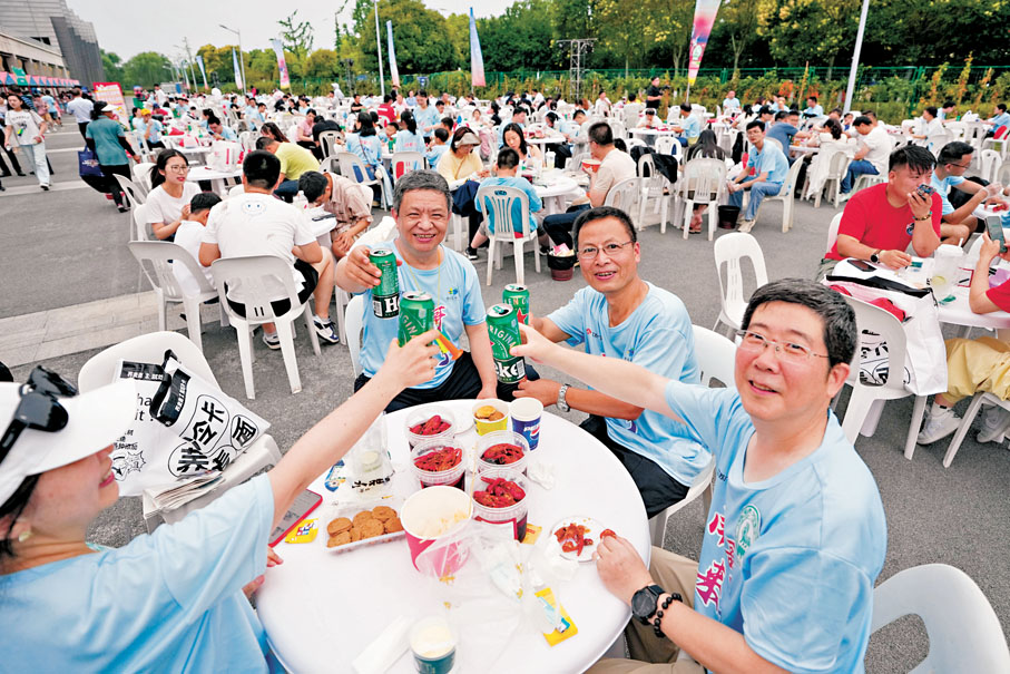 ●6月14日，球迷在江蘇淮安「蘇超」市集品嘗美食特產。新華社