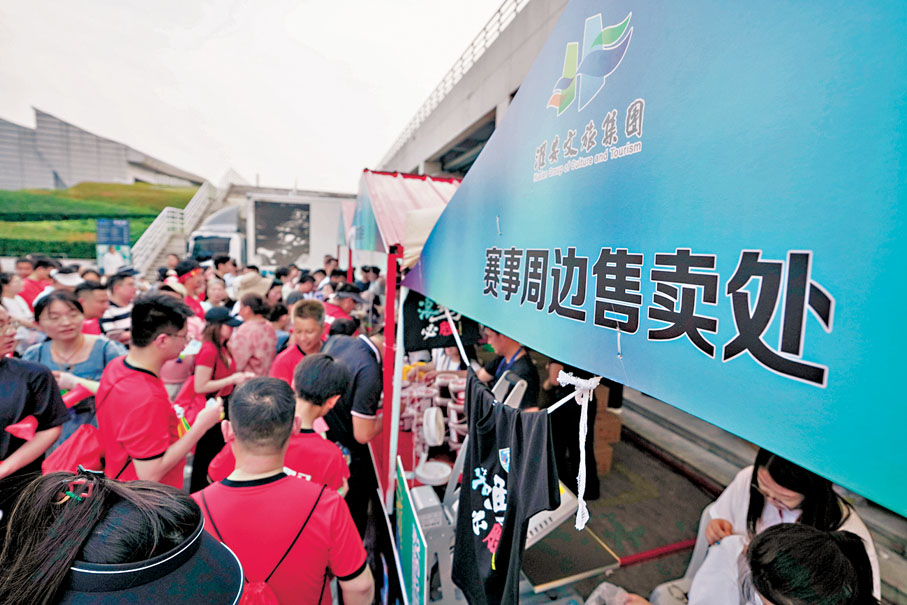 ●6月14日，球迷在江蘇淮安「蘇超」市集選購各類賽事周邊產品。新華社