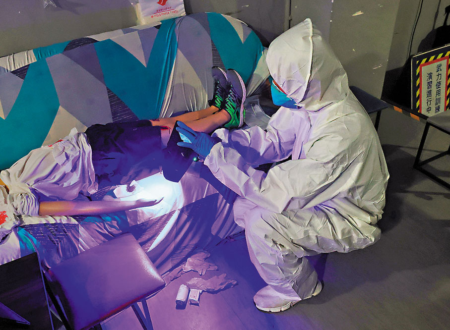 ●警方鑑證科人員示範在案發現場使用電子掃描儀等儀器進行蒐證。香港文匯報記者郭木又  攝