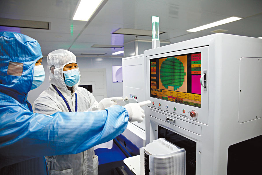 ●鄧勝斌（藍衣）在芯片生產車間查看生產情況。香港文匯報記者李陽波  攝