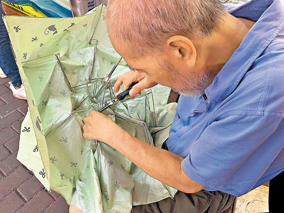 ●威哥為街坊們修理雨傘。 香港文匯報記者胡恬恬  攝