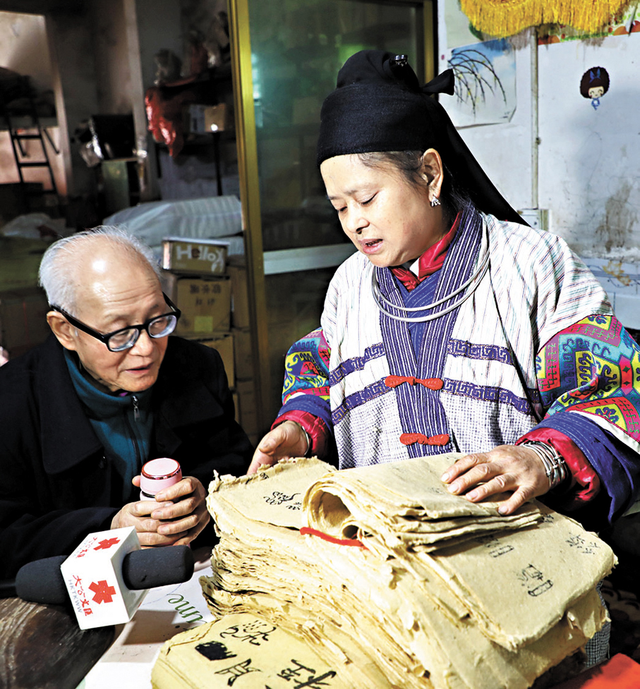 ●趙昌平（右）向她的小學老師饒慶發展示祭司作業。