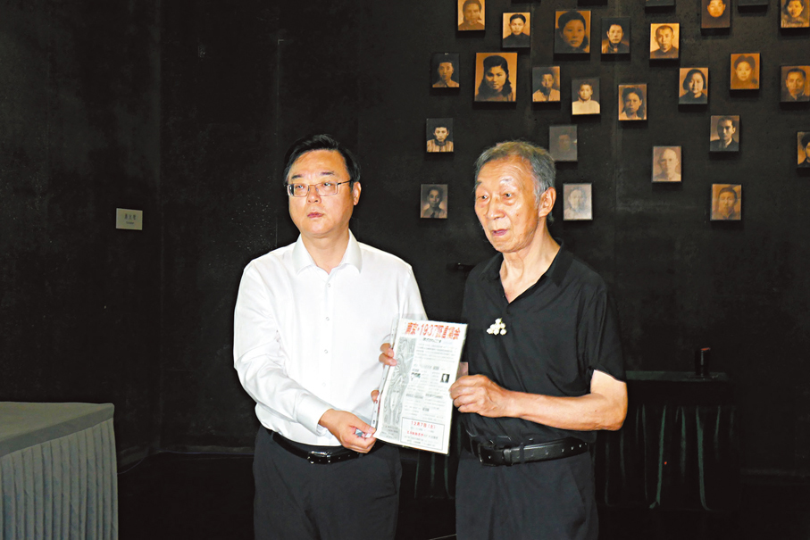 ●謝桂英的兒子姜忠榮（右）向侵華日軍南京大屠殺遇難同胞紀念館館長周峰捐贈母親去日本參加證言集會的資料。香港文匯報記者賀鵬飛  攝