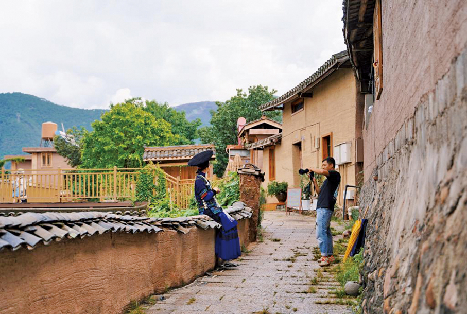 ●大石板村如今煥然一新，圖為身着民族服飾的遊客在拍攝寫真。 （新華社）