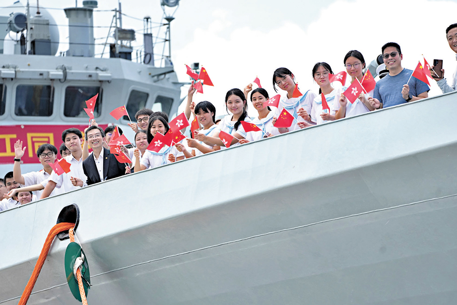 ●香港中學師生在艦艇上向岸上人群揮舞國旗和區旗。大公文匯全媒體記者蔡文豪  攝