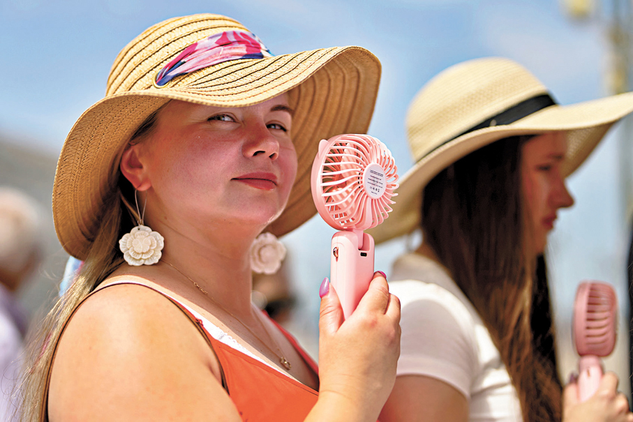 ●西班牙馬德里兩名女子拿着風扇乘涼。 美聯社