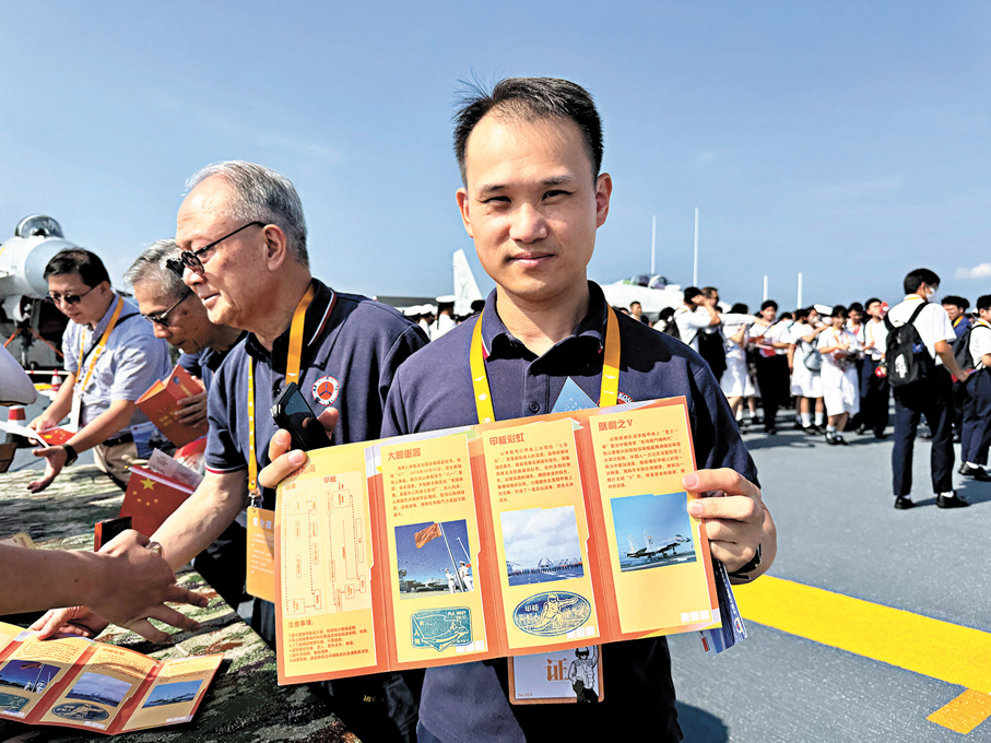 ●一位香港市民展示山東艦開放參觀手冊上的打卡標誌。 中新社